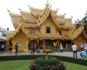 Das goldene Toilettenhaus am weißen Tempel in Thailand.