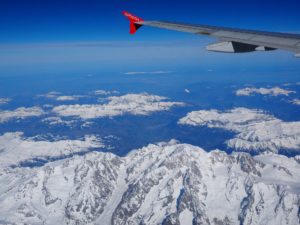 Ausblick aus einem Flugzeug auf schneebedeckte Berge.