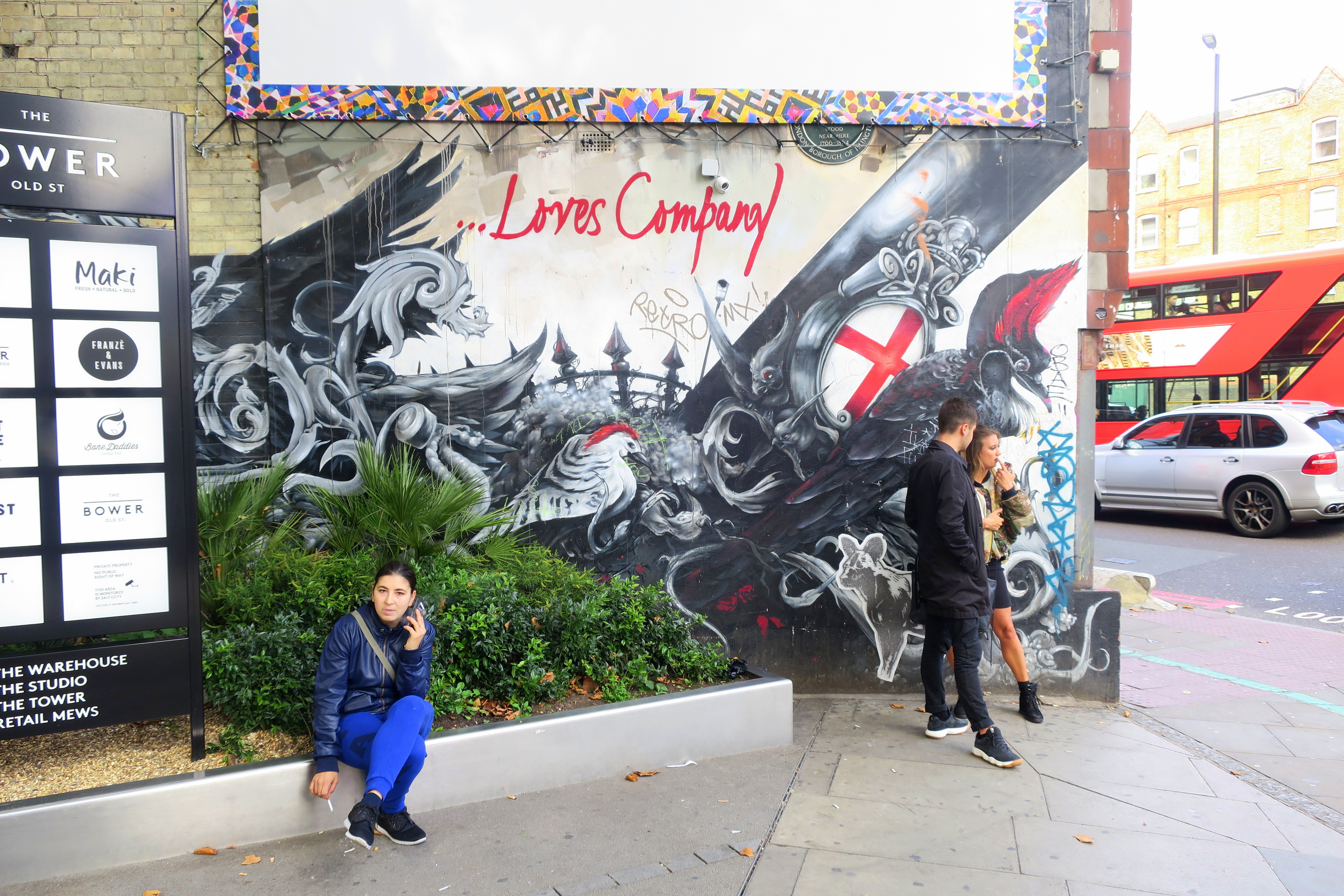 Menschen stehen vor einem Graffiti in Shoreditch in London 2017.