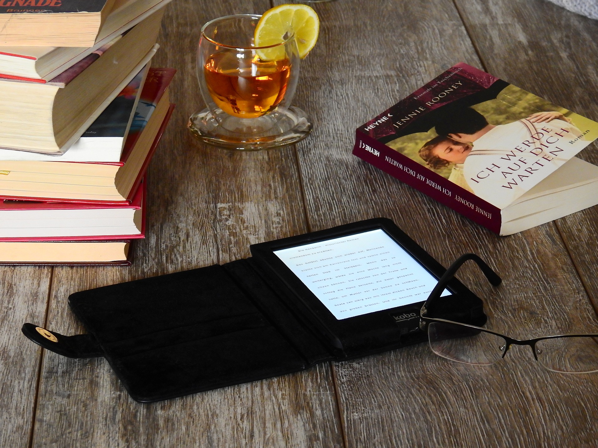 Ebook Reader und Bücher auf einem Tisch. Quelle: Pixabay
