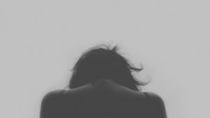 Eine traurige Frau senkt den Kopf. Bildquelle: Pixabay