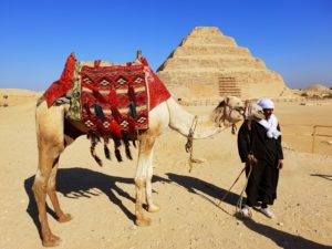 Ein Einheimischer mit Kamel vor der Saqqara-Pyramide in Ägypten, 2018.